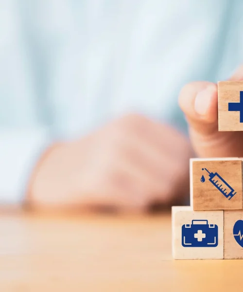 medico-poniendo-el-icono-de-atencion-medica-que-imprime-la-pantalla-en-el-apilamiento-de-cubos-de-madera-para-el-concepto-de-seguro-medico_11zon_11zon